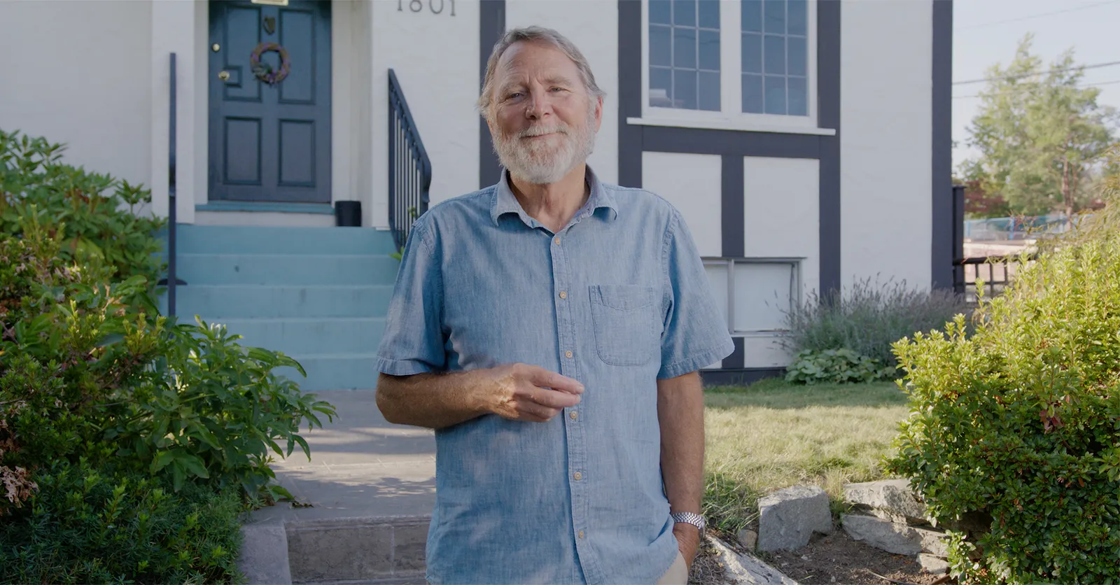 Older man smiling outside home