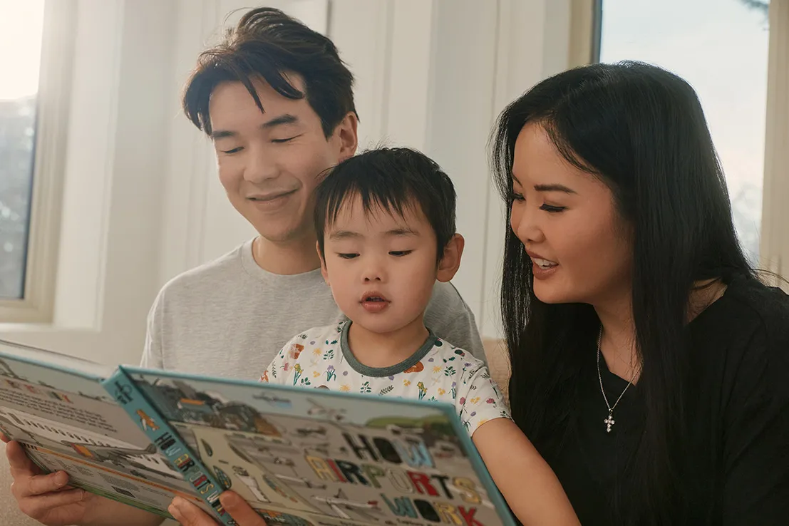 Family reading a children's book together at home