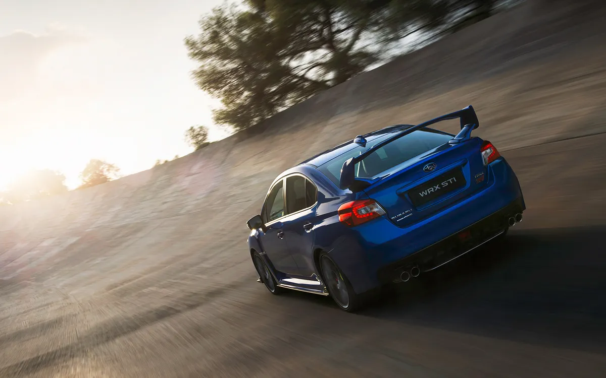 Subaru WRX STI driving on a sunlit road